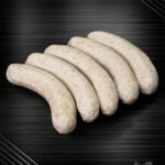 Fläming-Griller Bratwurst roh, grob und charakterstark – handwerklich inszeniert auf kühlem Metallhintergrund