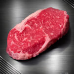 Rohes Rumpsteak Argentinien Black Angus mit natürlichem Fettrand auf dunklem Untergrund