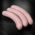 Fläming-Griller gepökelte Bratwurst, fein glänzend und zartrosa auf gebürstetem Metall – Sinnbild reinen Genusses