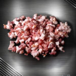 Gewürfelter Speck vom regionalen Duroc-Schwein im Rohzustand mit gleichmäßigem Fett- und Fleischanteil.