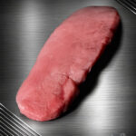 Rohes Schnitzel vom regionalen Duroc-Schwein mit feiner Marmorierung auf neutralem Untergrund.