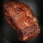 Rohes Schweinenackenstück für Pulled Pork, vakuumiert und fein marmoriert auf neutralem Untergrund.