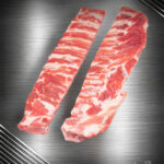 Rohe Baby Back Ribs vom regionalen Strohschwein mit feiner Fleischauflage auf hellem Untergrund